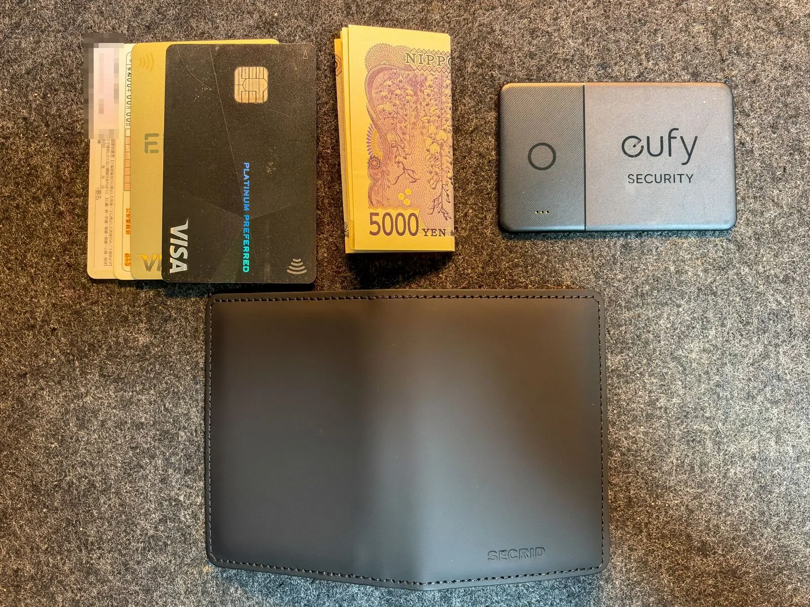 SECRID から出したカード 4 枚、折ったお札、eufy のカード型トラッカー